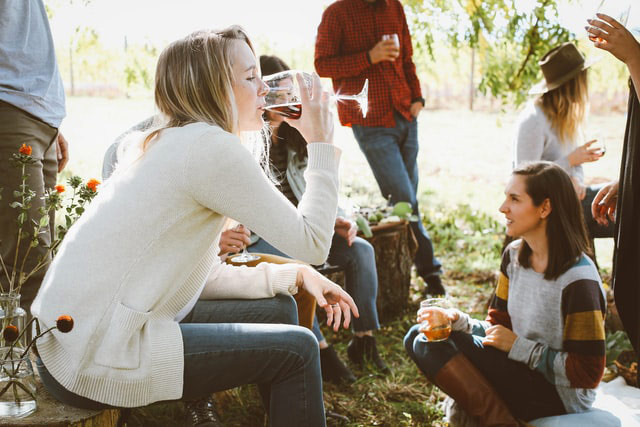 Group of people drinking wine in a sunny yard